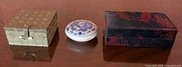 Three closed containers: two brocade boxes and one porcelain ink pot