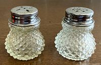 Pair of diamond-cut glass shakers front view