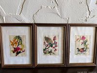 Group shot of three framed embroidered art pieces