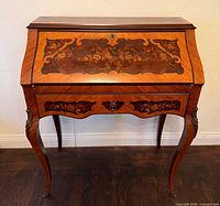 Front view showing roll top, marquetry and drawer