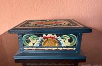 Front view of carved and painted wooden box