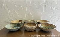 Six ceramic stoneware bowls on tabletop (group shot)