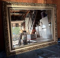 Front view of rectangular gold-gilt mirror showing ornate frame and beveled glass