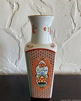 Front view showing floral-bird panel, geometric borders, gilt rim