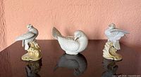 Front view of three porcelain dove figurines