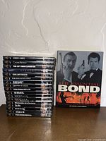 Full lot: stack of DVDs beside Essential Bond book