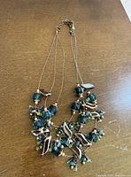 Full view of three-strand glass bead necklace laid flat