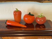 Front view of all four glass vegetables on wooden shelf