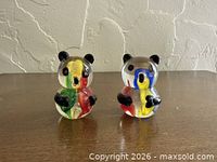 Front view of both glass panda bear figurines showing multicolored interiors