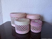 Front view of all four woven baskets with lids