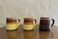Three ribbed stoneware mugs displaying color variations