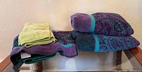 Stacked towels on glass table showing colors and patterns