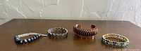 All four bracelets lined up on table