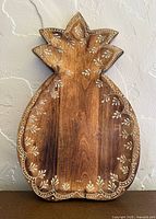 Front view of carved wooden pineapple tray showing full shape and decoration