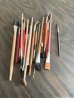 Group of approx. 18 paint brushes of varied sizes on tabletop