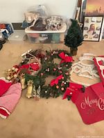 Assorted Christmas decor laid out including tree, wreath, ornaments, skirts, lights