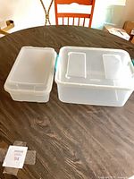 Small and medium clear IRIS storage boxes with lids shown side by side on table