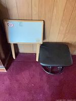 Tray table leaning against wall next to ottoman