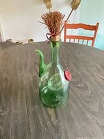 Full view of green glass cruet with cork stopper in place