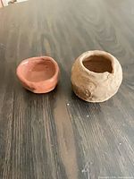 Both clay vessels side by side on table