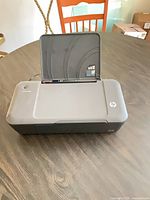Front view of HP Deskjet 1000 printer, input tray raised