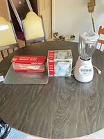 Overview of boxed Hamilton Beach knife, Rival can opener box, glass cutting board and assembled Oster blender