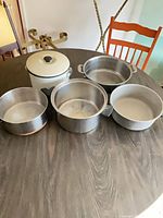 Five assorted pots displayed upright