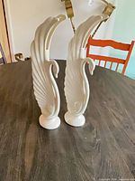 Front view of both ceramic swan figurines on table