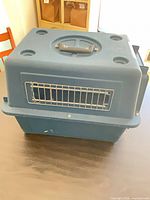 Top view showing blue hard-plastic kennel, molded handle and ventilation