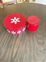 large and medium tins side by side with lids on