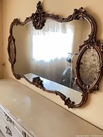 Full view of ornate rectangular mirror above dresser
