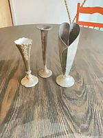 All three metal bud vases side by side