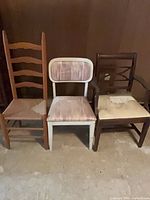 Front view of three assorted wooden chairs side by side