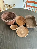 All five assorted wicker and rattan baskets grouped together