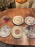 Group shot of six commemorative plates on table
