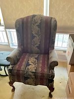 Full front view of upholstered wingback armchair