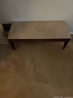 Full view of the coffee table showing marble top and wooden legs