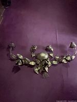 Full view of brass floral wall sculpture on wall