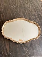 Full view of gold-finish mirrored vanity tray showing size and crack