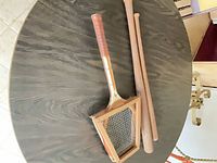 Overhead view showing tennis racket in wood press and two wooden baseball bats