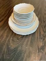 Stack showing saucers, bowls, dinner plates with fluted rim
