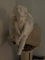 Front angled view of seated plaster cherub angel figurine