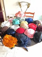 Overall group of 16 women’s dress hats on table