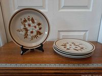 One dinner plate on stand and four stacked, ruler shows scale