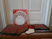 Full lot showing plaid linens, Artistic doilies package, stocking pot holder