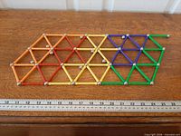 Complete set arranged flat in geometric pattern beside ruler for scale