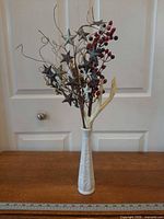 Full view of milk glass vase with arrangement on tabletop