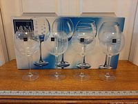 Front view of all four Mikasa Cheers glasses in front of original box