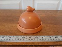 Garlic baker with lid on, ruler for scale