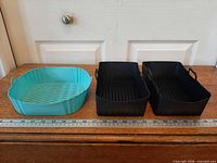 Three silicone air fryer liners side by side with ruler for scale
